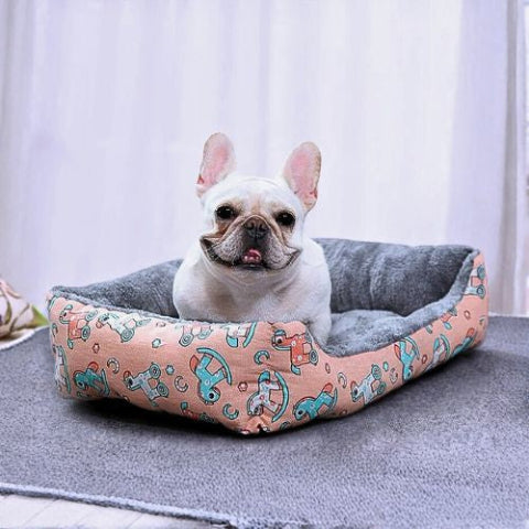 bouledogue français assis confortablement dans panier pour chien rose chouette