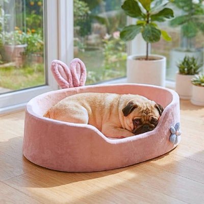 Carlin endormi dans un couchage chien Rosi rose anti-stress