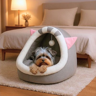 Yorkshire terrier couché dans un couchage pour chien Coquino gris semi-fermé