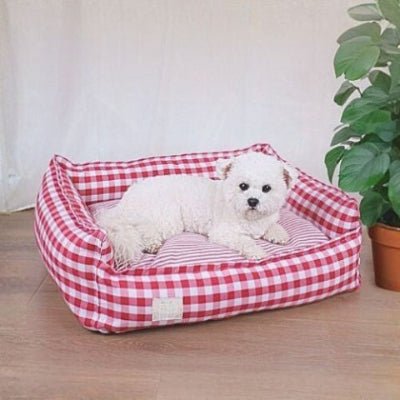 Caniche toy couché dans un panier chien Cocooning rouge déhoussable et lavable