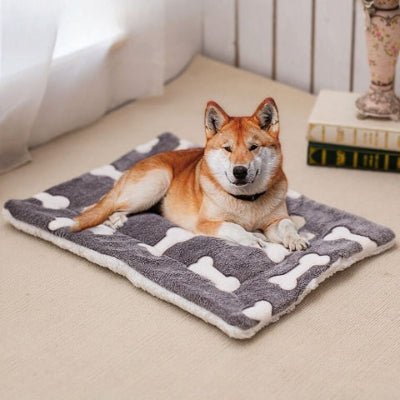 shiba inu couché sur un tapis chien noir et os en polaire flanelle et corail