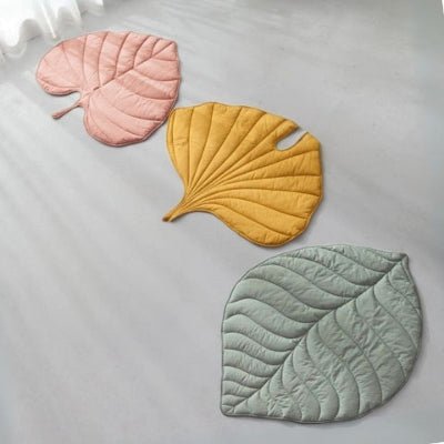 Trois tapis pour chien Farfel rose jaune et vert côte à côte sur un plancher